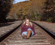 Sitting on the tracks in her jeans in the fall from on the tracks