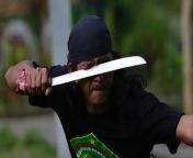 Tangerang, Indonesia; A man slashes at his eyes with a machete as he performs the martial art of debus from indonesia xxx tuyul mohawk