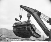 Hiro, Japan. 1953-01-20. British Commonwealth Movement Control Group with the aid of a mobile crane lifts a 52 ton Centurion tank into mid air before loading it onto a rail carriage at the railway station for transport to Haramura. from thiendia com satomi hiro