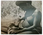 Papua New Guinean Tribeswoman feeds a pig from her breast. In days gone by it was common for women to keep one breast for their children and one for the family pig, reared for meat for very low cost. from breast feeds
