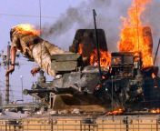 A British soldier jumps from a burning tank which was set ablaze by a petrol bomb thrown by angry Iraqi citizens in the southern Iraqi city of Basra. 19 September 2005. from sec iraqi
