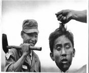 The severed head of North Korean Communist guerrilla held up by a member of the South Korean National Police, Cholla Poktuk, South Korea, November 17, 1952 [559x690] (nsfw) from nepali south korea kanda