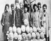 Iranian soldiers pose with the straw-stuffed heads of Mohammad Ali Shah-allied Turkmen chiefs they killed in battle, photographed here after their delivery to Tehran, c. 1911. from iranian