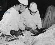 France December 1944; in a US Army field hospital, a surgical team examines a damaged arm before making the decision on amputation. from us army a