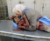 A greiving woman takes her dead 6 year old son into her arms. Dhiya Thamer was killed when their family car came under fi e by an unknown gunman in Baqouba, Iraq 2007. Family returned from enrolling the chlildren f on school, where Dhiya was to begin hisfrom his owner son sex her