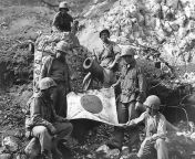 U.S. Marines (Left to Right), PFC. J. L. Hudson Jr. Pvt. K.L. Lofter, PFC. Paul V.Parces, (top of blockhouse), Pvt. Fred Sizemore, PFC. Henrey Noviech and Pvt. Richard N. Pearson pose with a captured Japanese flag on top of enemy pillbox. from dev pvt lt