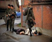 Arkan&#39;s tigers soldier kicks a dead bosnian woman. photo by Ron Haviv from arkan