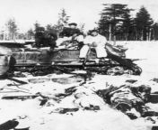 Finnish soldiers are sitting on the hull of a knocked out T-34 tank. In front of the hull are dead Soviet soldiers. Near the village of Velikaya Guba (Fin. Suurlahti) in Karelia. 1942 from village in front baby