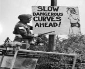 A Canadian MP nails a sign warning of a dangerous road section ahead, somewhere in France, June/July 1944. from mp liv