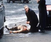 [NSFW] A catholic priest gives last rites to a British soldier who was shot, then stripped naked by IRA in Belfast, 1988. from www taboo by primal