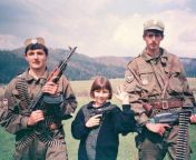 A little girl holding a handgun, and showing the three-finger salutetwo young Serb volunteers and a little girl pose for a camera during the Yugoslav Wars (Xpost r/UnchainedMelancholy) from blacks girl striped on a camera