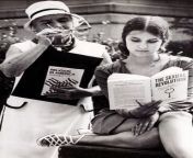 Young woman reading Wilhelm Reich&#39;s The Sexual Revolution, while an older woman, holding William G. McLoughlin&#39;s Religion in America, tries to have a peek at it. San Francisco, 1968. from young woman necropsy